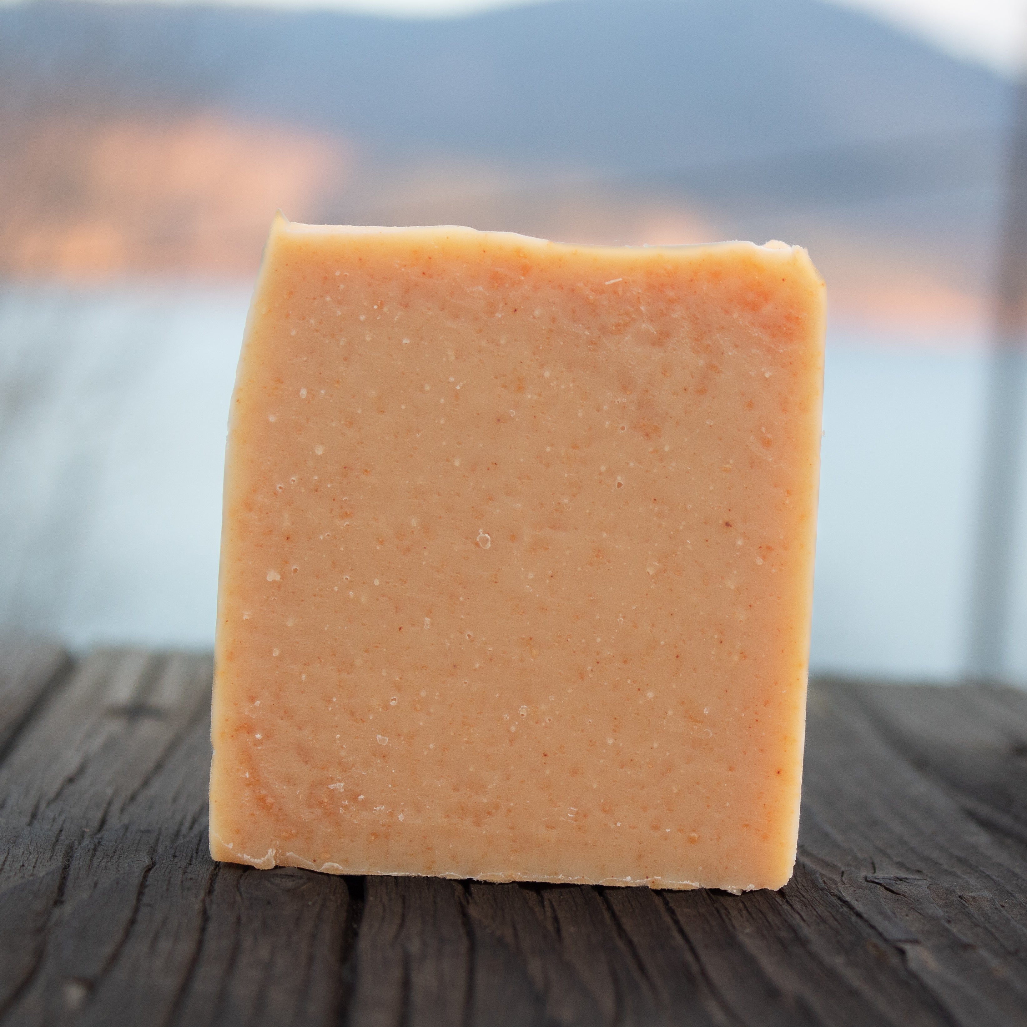 Light colored soap bar with tumeric background with sky and mountain 